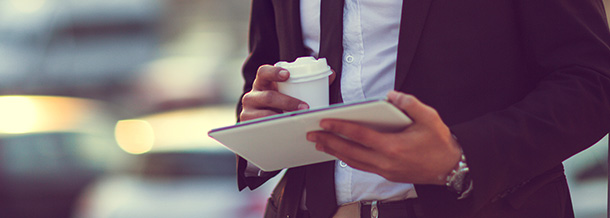 Geschäftsmann mit Tablet und Coffee-to-go-Becher